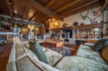 Rustic mountain home with beamed ceilings, stone fireplace, and antique furnishings.