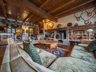 Rustic mountain home with beamed ceilings, stone fireplace, and antique furnishings.