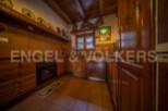 Rustic kitchen with wooden cabinets and terracotta tile floors.