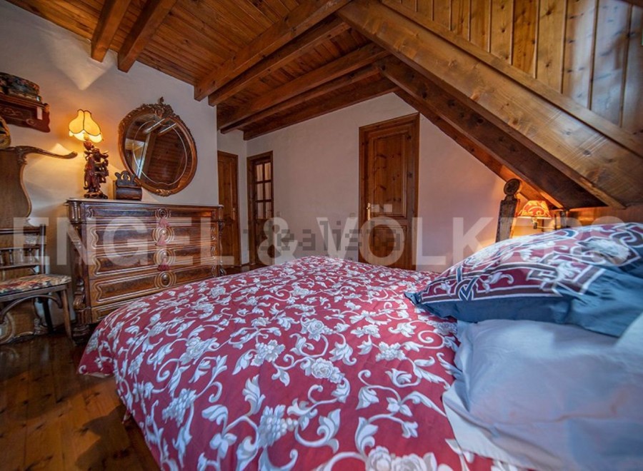 Charming attic bedroom with wooden beams and antique furniture.