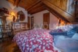 Charming attic bedroom with wooden beams and antique furniture.