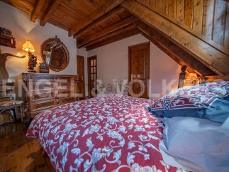 Charming attic bedroom with wooden beams and antique furniture.