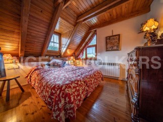 Cozy attic bedroom with wooden beams and hardwood floors.