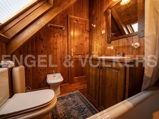 Charming wooden bathroom with a bathtub, toilet, bidet, and sink.