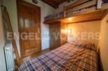 Cozy chalet bedroom with a built-in bunk bed and plaid bedding.