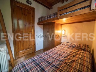 Cozy chalet bedroom with a built-in bunk bed and plaid bedding.
