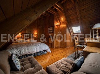 Cozy attic bedroom with wooden beams and hardwood floors.