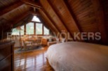 Cosy attic bedroom with wooden beams and mountain views.