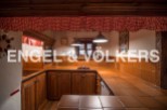 Rustic kitchen with wooden cabinets and terracotta tile countertops.