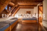 Charming attic bedroom with wooden beams and twin beds, offering a cozy and rustic atmosphere.