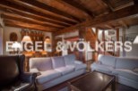 This stunning chalet boasts a spacious living area with exposed wooden beams, creating a warm and inviting atmosphere.