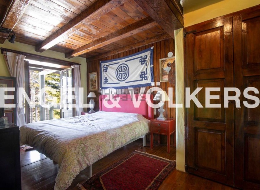 Discover this charming bedroom with wooden beamed ceilings and a cozy atmosphere.