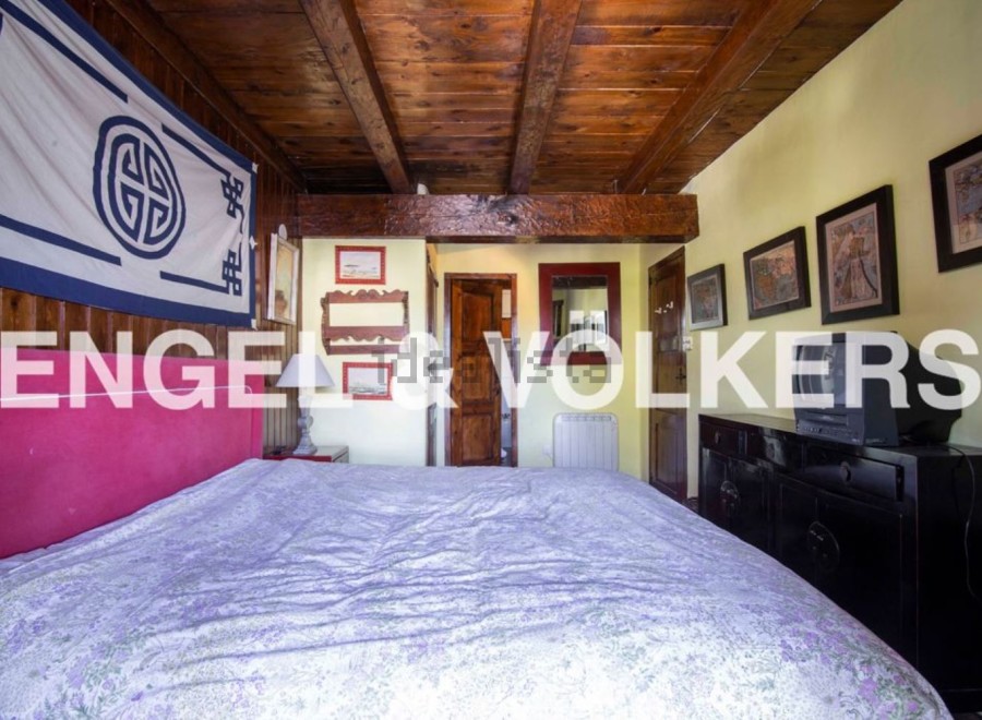 Charming bedroom with wooden beamed ceiling and unique decor.