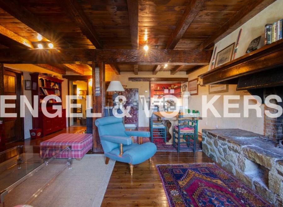 Rustic mountain home with exposed wooden beams, a large stone fireplace, and ample living space.