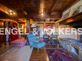 Rustic mountain home with exposed wooden beams, a large stone fireplace, and ample living space.