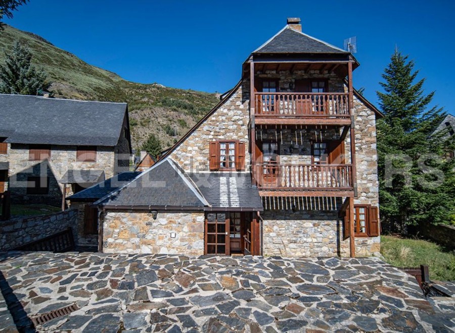 This charming stone house boasts two levels with balconies, offering stunning mountain views.