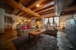 Cozy living room with wooden beams, a fireplace, and comfortable sofas.