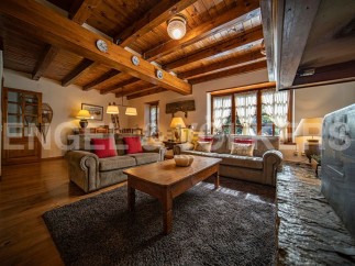 Cozy living room with wooden beams, a fireplace, and comfortable sofas.