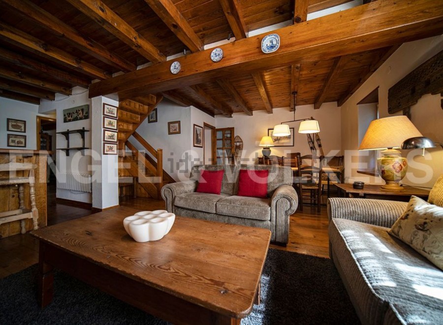 Charming chalet with exposed wooden beams and a cozy living area, perfect for a relaxing mountain getaway.