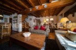 Charming chalet with exposed wooden beams and a cozy living area, perfect for a relaxing mountain getaway.