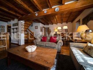 Charming chalet with exposed wooden beams and a cozy living area, perfect for a relaxing mountain getaway.