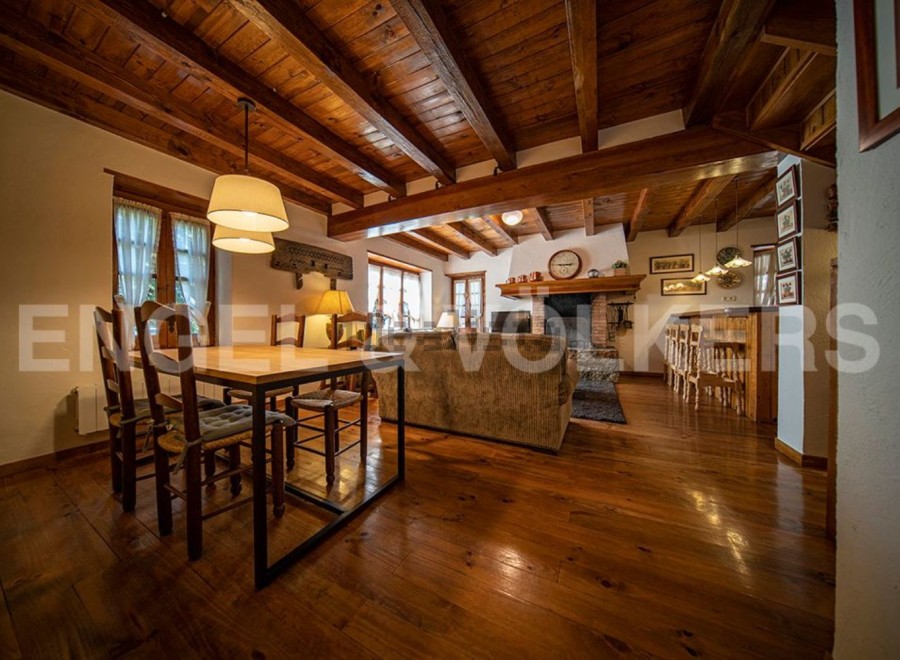 Rustic mountain home with exposed wooden beams, a cozy fireplace, and a spacious open-plan living area.