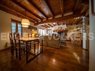 Rustic mountain home with exposed wooden beams, a cozy fireplace, and a spacious open-plan living area.