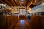 Rustic kitchen with wooden beams, wooden cabinets, and granite countertops.