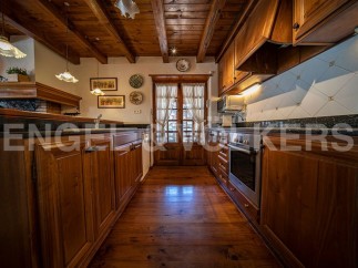 Rustic kitchen with wooden beams, wooden cabinets, and granite countertops.
