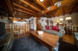 Cozy chalet apartment with exposed wooden beams, a rustic kitchen, and a comfortable living area.