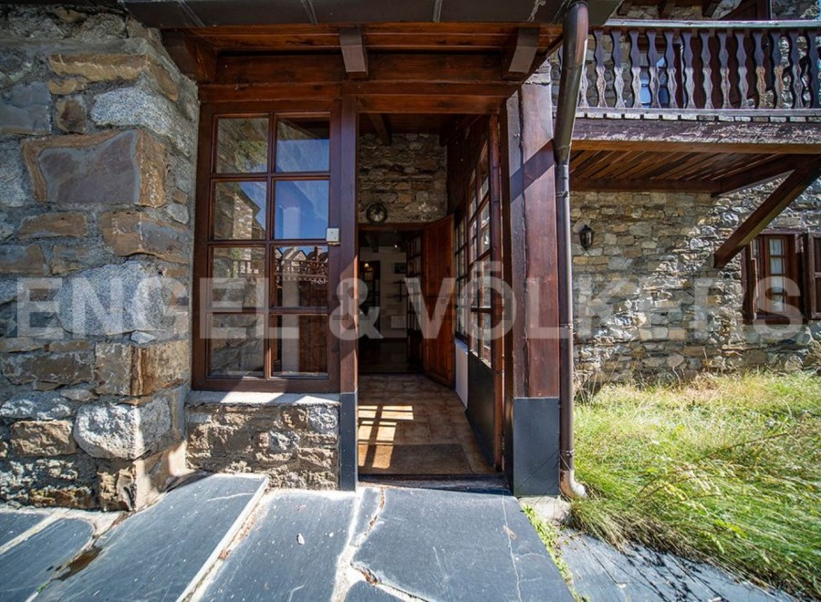 This charming stone house boasts a rustic wooden entrance, leading to a cozy interior.