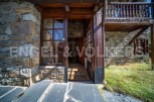 This charming stone house boasts a rustic wooden entrance, leading to a cozy interior.