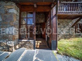 This charming stone house boasts a rustic wooden entrance, leading to a cozy interior.