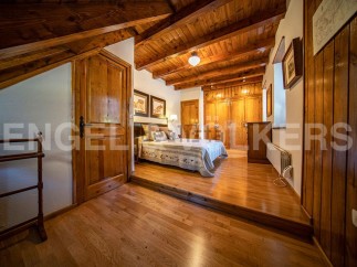 This charming bedroom boasts a rustic wooden interior with exposed beams and hardwood floors.