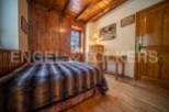 Cozy wooden bedroom with a plush fur throw on the bed, offering a warm and inviting atmosphere.