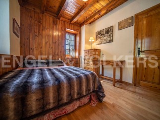 Cozy wooden bedroom with a plush fur throw on the bed, offering a warm and inviting atmosphere.