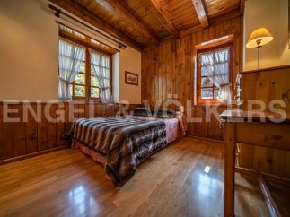 Cozy wooden bedroom with two windows offering ample natural light.