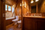 This charming bathroom boasts a rustic wooden design, complete with a bathtub, toilet, and bidet.