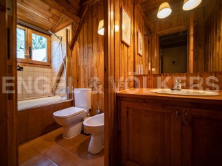 This charming bathroom boasts a rustic wooden design, complete with a bathtub, toilet, and bidet.