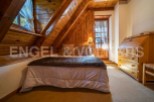 Cozy attic bedroom with wooden beams and a comfortable bed.