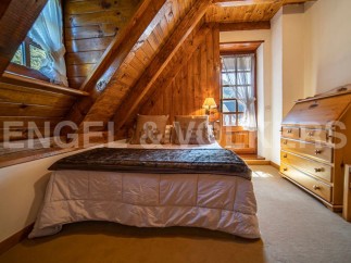 Cozy attic bedroom with wooden beams and a comfortable bed.