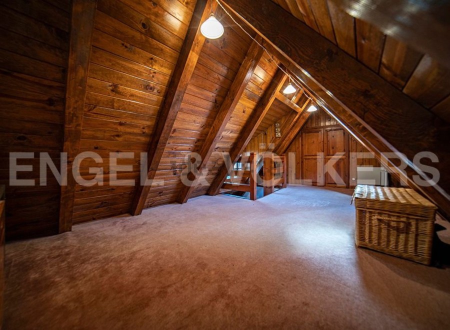 Discover this unique attic space, boasting a charming wooden interior and ample natural light.