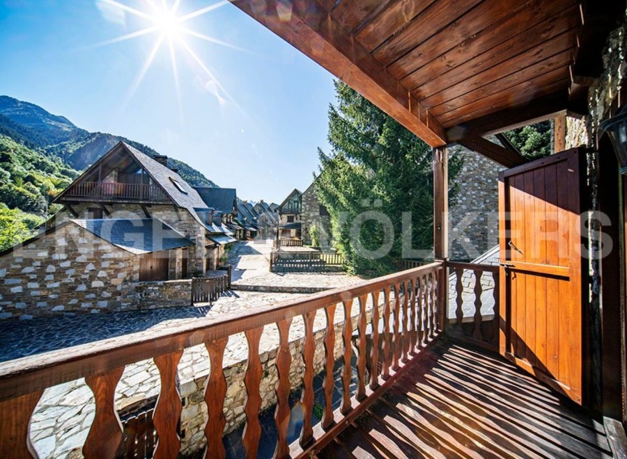 This stunning property boasts a picturesque balcony overlooking a charming village nestled in the mountains.