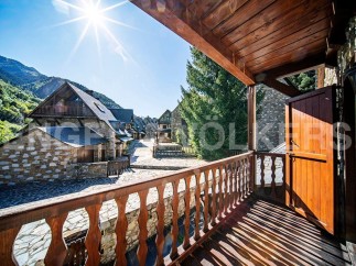 This stunning property boasts a picturesque balcony overlooking a charming village nestled in the mountains.