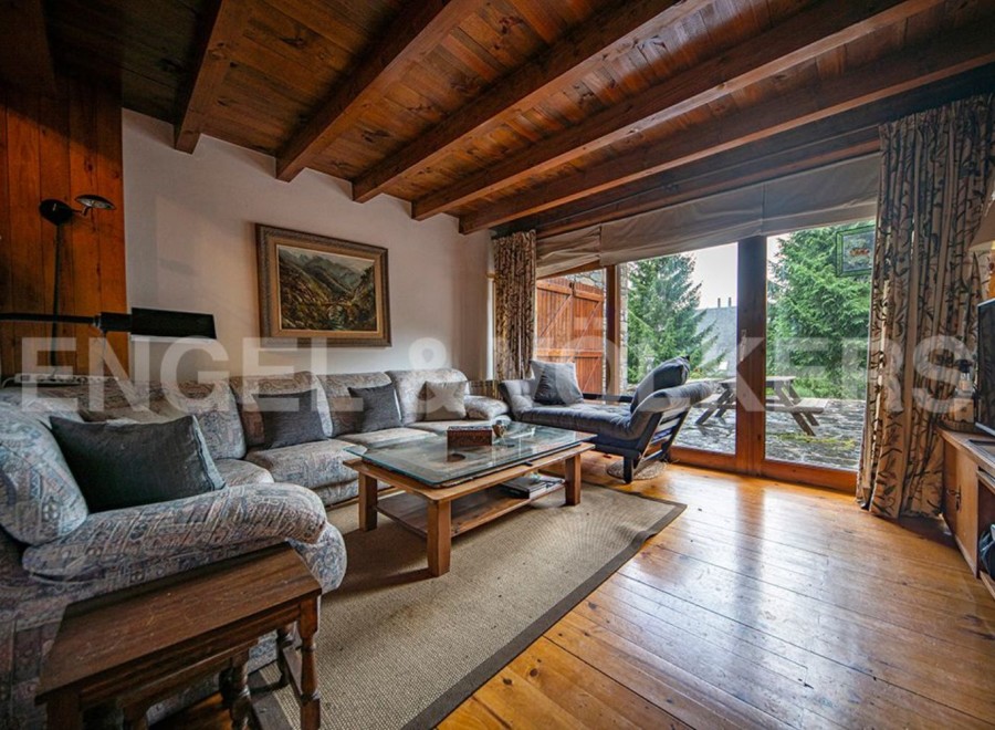 This stunning chalet boasts a spacious living area with large windows offering breathtaking views.