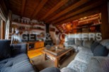 Cozy mountain chalet with rustic wooden beams and a large sectional sofa perfect for relaxing after a day of outdoor activities.
