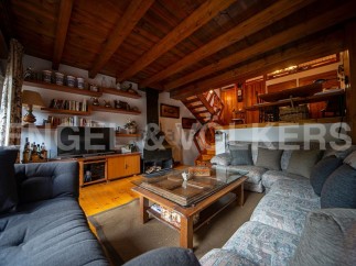 Cozy mountain chalet with rustic wooden beams and a large sectional sofa perfect for relaxing after a day of outdoor activities.