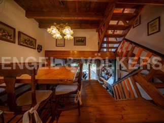 Charming wooden chalet with a spacious dining area and stunning wooden staircase.
