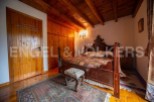 This charming bedroom boasts a rustic wooden bed, wooden floors, and built-in wooden wardrobes.