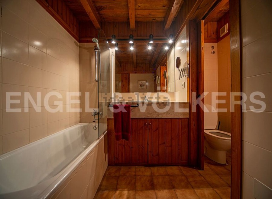 Charming bathroom with wooden finishes and a bathtub.